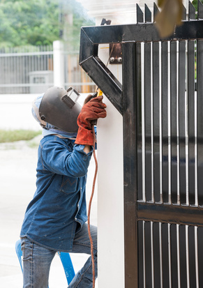 Contractor Supporting Services: sparking worker working on metal gate
